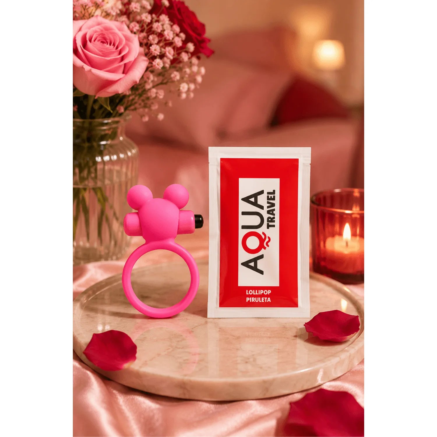 Anneau vibrant rose ourson en silicone hypoallergénique sur table avec roses et bougie, idéal pour stimulation clitoridienne.