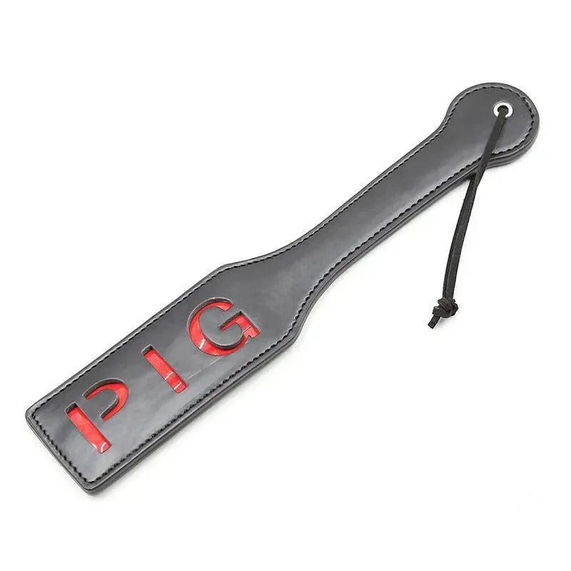 Accessoire BDSM paddle noir avec inscription PIG rouge, design élégant et sans phtalates pour moments intimes sécurisés.