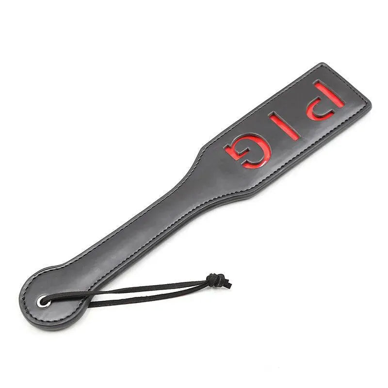 Paddle BDSM noir avec inscription PIG rouge, accessoire sans phtalates, design ergonomique par Ohmama.