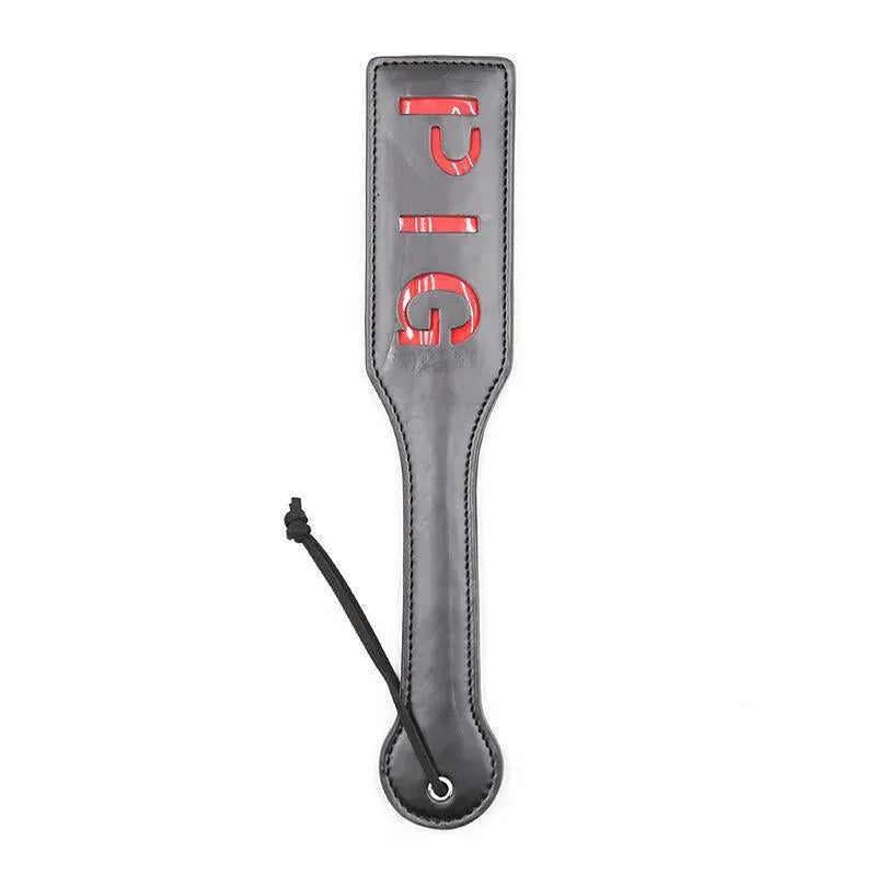 Paddle BDSM noir avec inscription rouge PIG, design ergonomique, sans phtalates, accessoire intime de qualité.