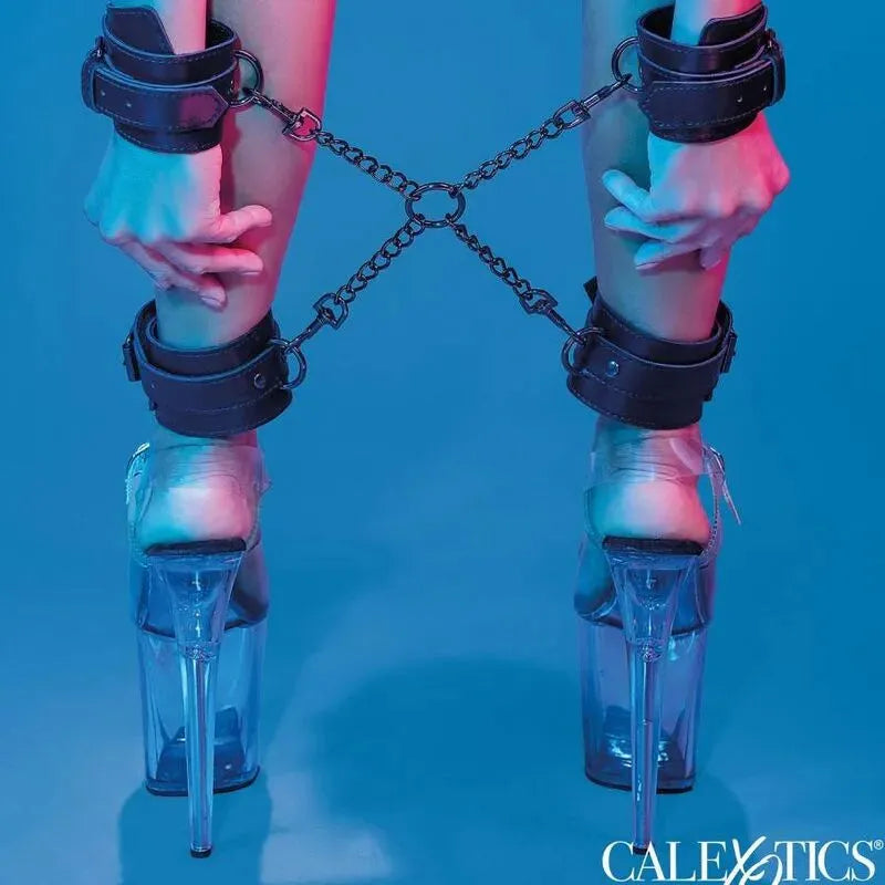 Accessoire BDSM cuir végétalien noir avec menottes réglables et connecteur en chaîne, fond bleu, style élégant.