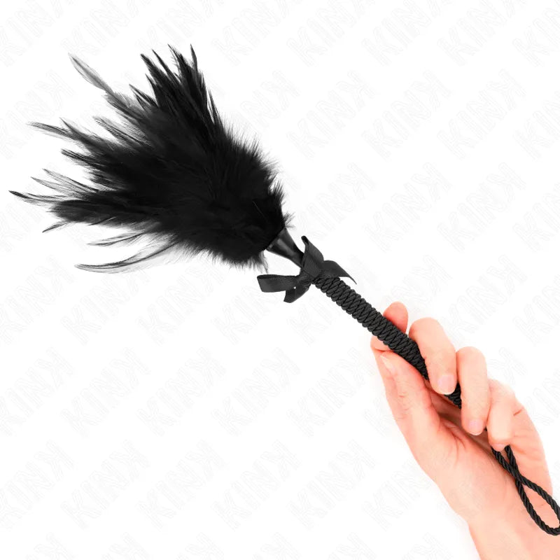 Accessoire BDSM en cuir noir, cravache élégante avec manche tressé et plume douce, pour jeux de rôle sophistiqués.