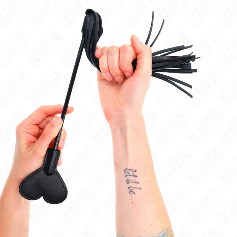 Accessoire BDSM en cuir noir, fouet à lanières et cœur, tenu par une main, élégance et durabilité.