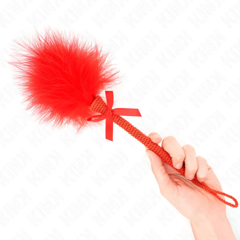 Accessoire BDSM en cuir rouge avec plume, design élégant et raffiné, idéal pour jeux intimes sophistiqués.