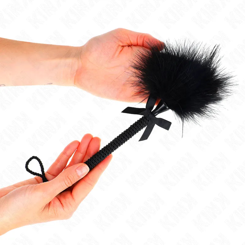 Accessoire BDSM haut de gamme: plumeau en cuir noir avec manche tressé, élégant et raffiné pour expériences sensorielles.