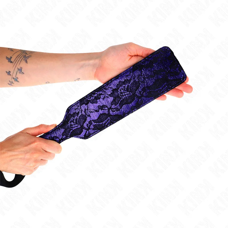 Accessoire BDSM haut de gamme en cuir noir, cravache élégante avec détails raffinés, tenue en main.
