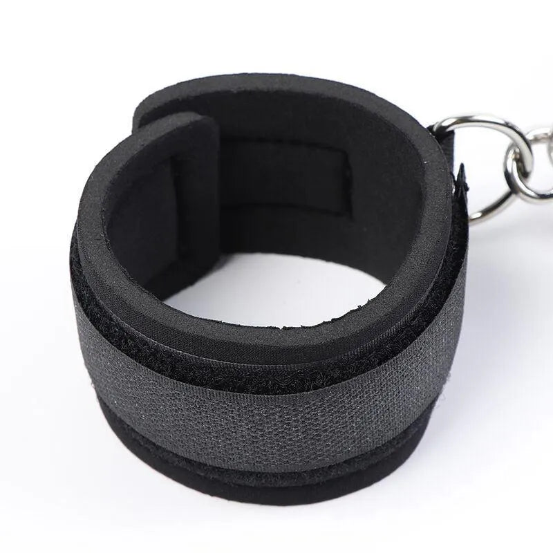 Bâillon noir ajustable avec menottes en tissu doux, idéal pour débutants explorant le fétichisme en toute sécurité.
