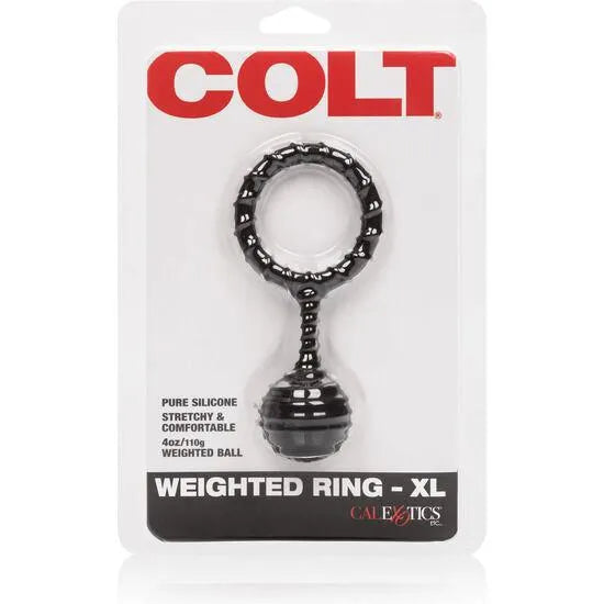 Bague en silicone noire lestée, forme circulaire avec boule, pour intensifier les orgasmes, sur fond d'emballage blanc.