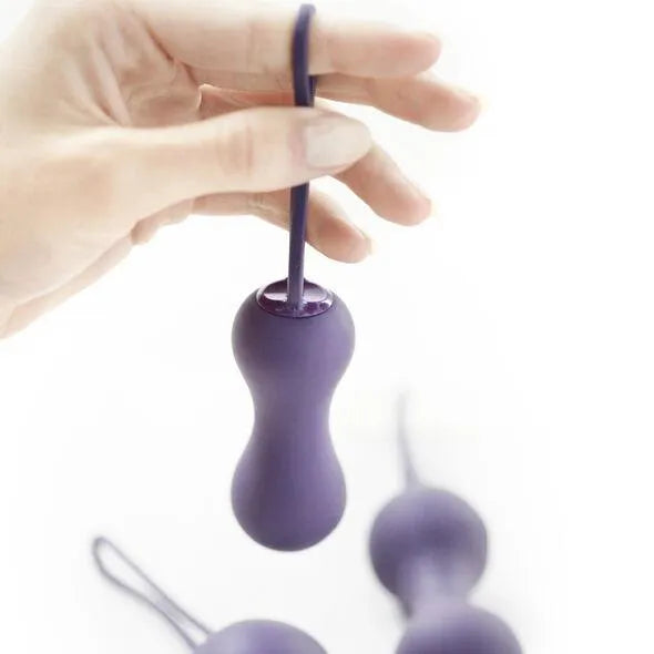 Balle de Kegel lilas pour tonification pelvienne, forme ergonomique, avec cordon, trois poids progressifs visibles.