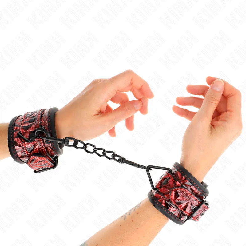 Bandes de poignet BDSM en cuir végétalien rouge élégant avec motifs, attachées par une chaîne noire, design éthique et stylé.