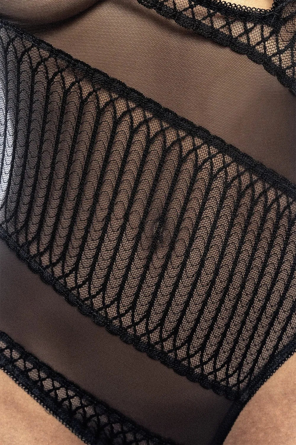 Body asymétrique noir avec dentelle géométrique et résilles transparentes, design élégant et tendance pour femme.