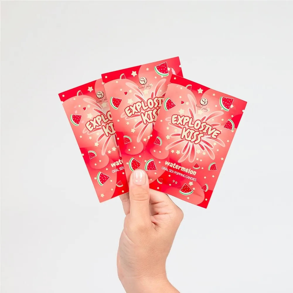 Bonbons pétillants pastèque pour sexe oral, emballage rouge avec motifs pastèque, main tenant trois sachets.