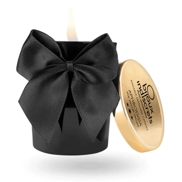 Bougie de massage noire avec ruban, couvercle doré, parfum aphrodisiaque, ambiance sensuelle et exotique.