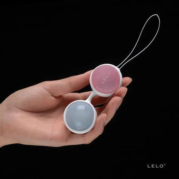 Boules Kegel ajustables roses et bleues pour renforcement pelvien post-partum, tenues en main, avec système de poids inter...