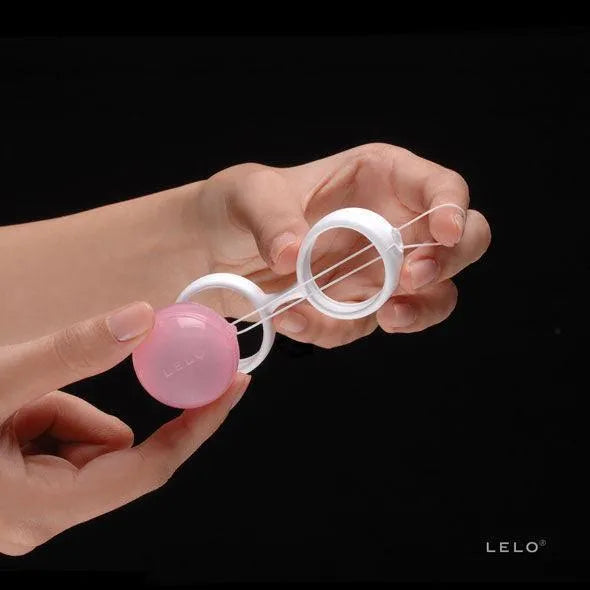 Boules Kegel roses ajustables avec poids interchangeables pour renforcement pelvien post-partum, tenues en main.