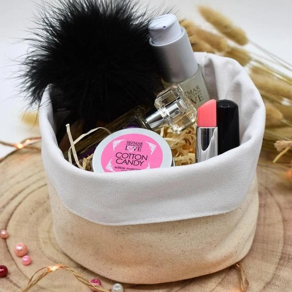 Box cadeau bien-être naturelle avec produits de beauté, flacon, baume, rouge à lèvres, sur fond bois et décor floral.