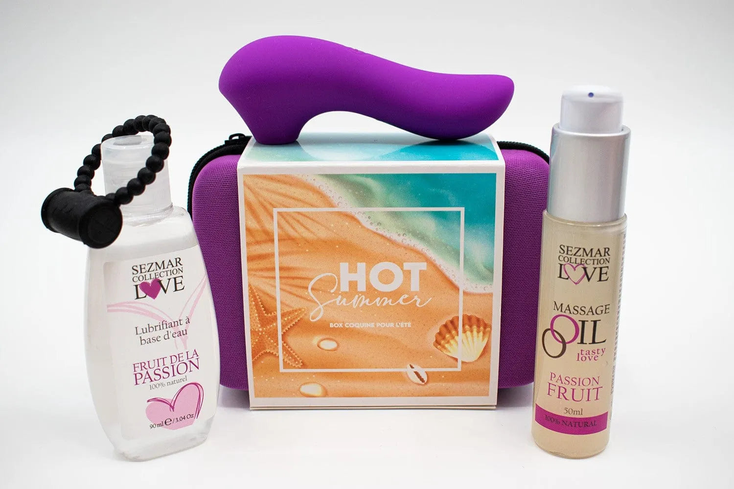 Box Couple Été Passion avec stimulateur violet, huile de massage fruitée et lubrifiant, sur fond estival.