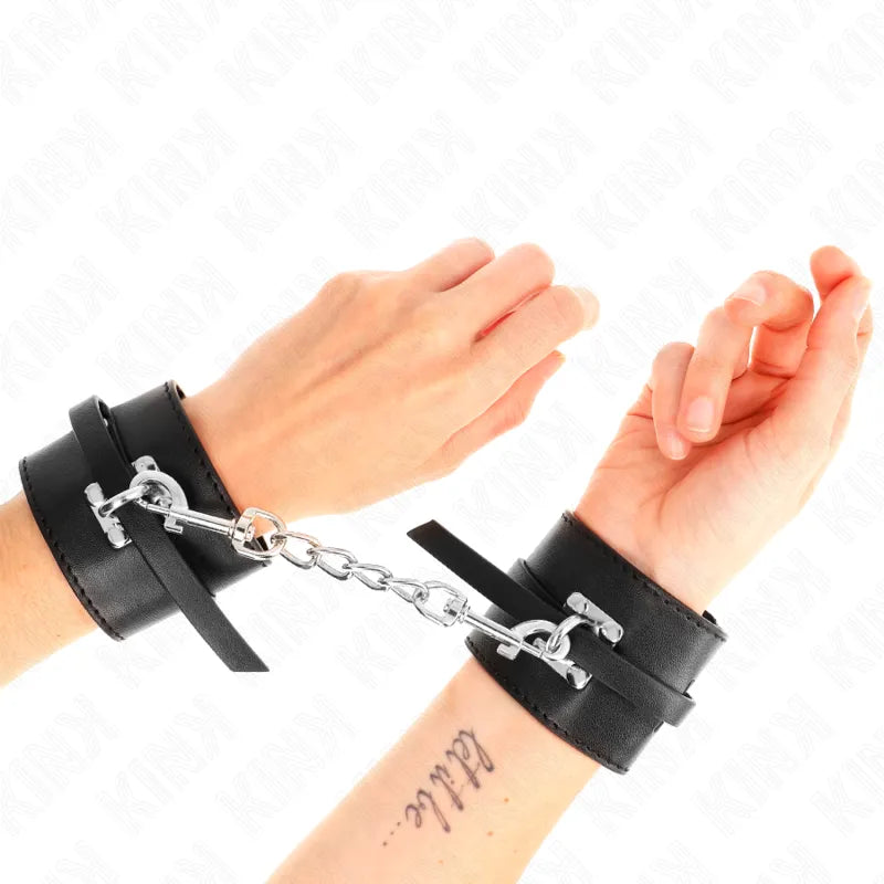 Bracelets BDSM en cuir végétalien noir avec chaîne métallique, portés sur poignets, élégants et éthiques.