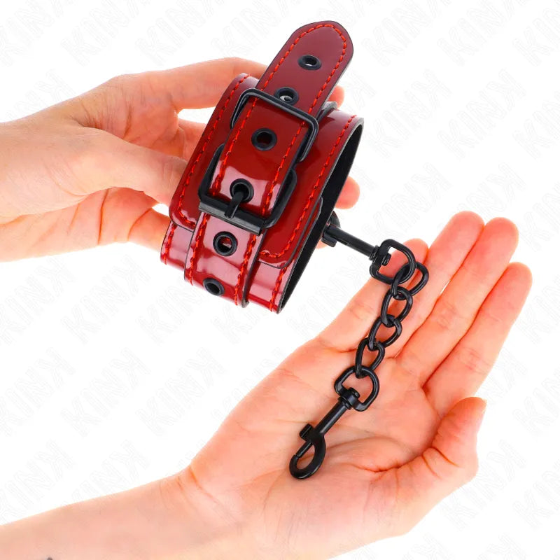 Bracelet BDSM en cuir rouge avec boucle noire, chaîne métallique, design élégant et sécurisé pour moments de complicité.