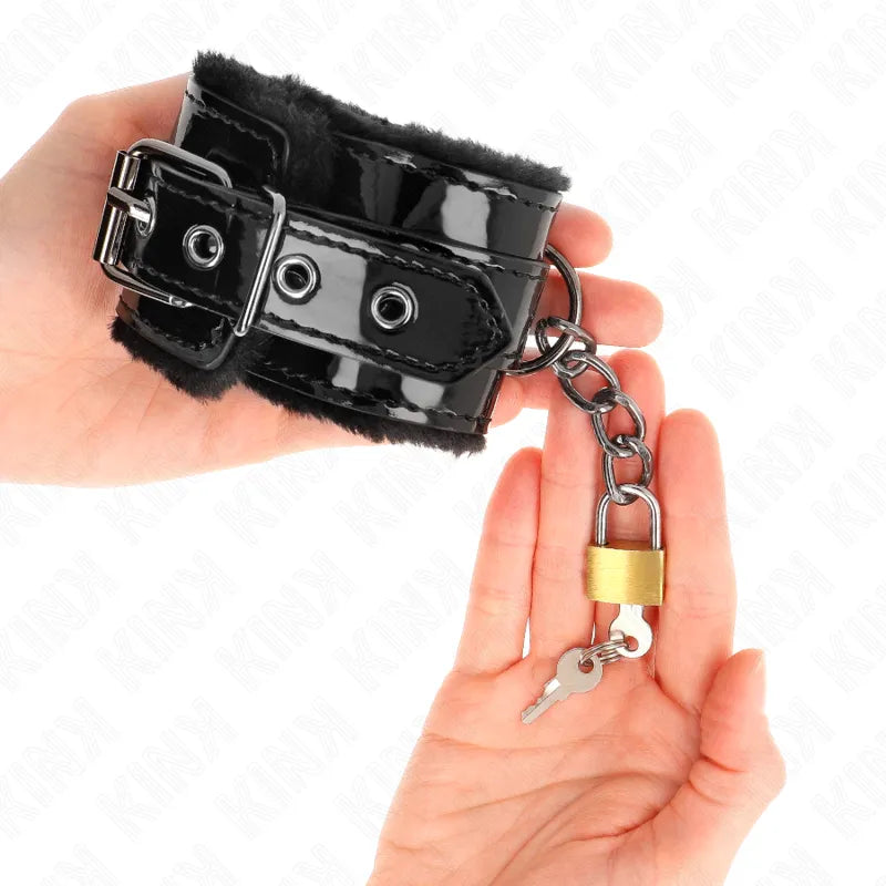 Bracelet BDSM en cuir noir brillant avec doublure douce, chaîne métallique et serrure, pour confort et sécurité.