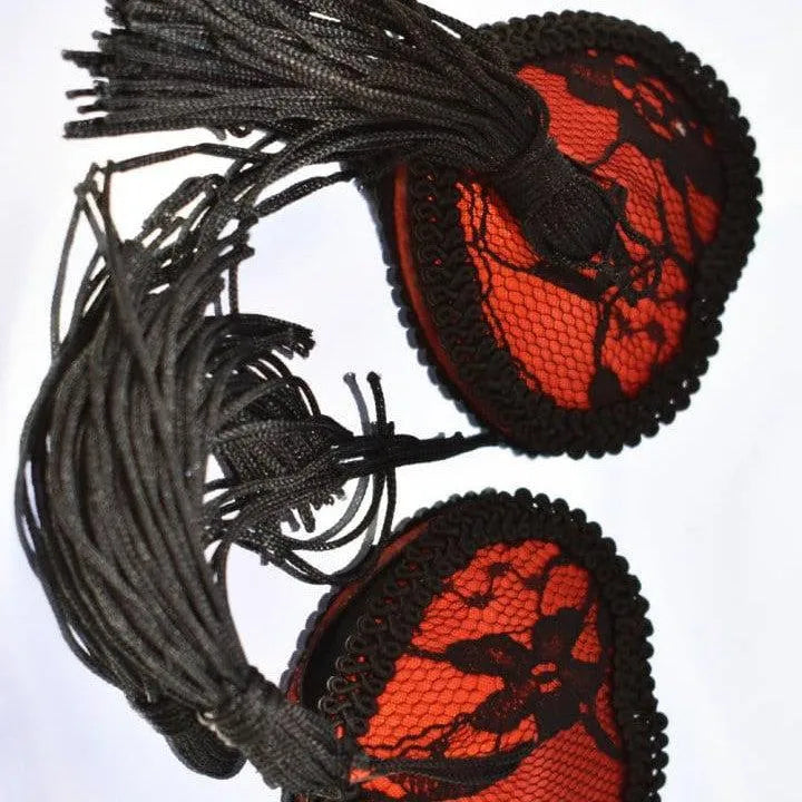 Cache-tétons cœur rouge en dentelle noire avec franges, accessoire glamour et élégant pour soirées spéciales.