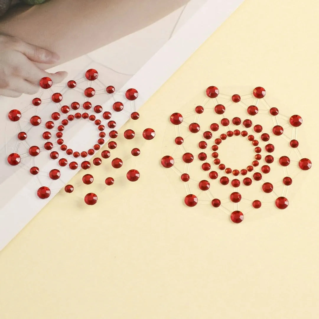 Cache-tétons réutilisables en strass rouges, forme circulaire élégante, adhérence fiable, sur fond beige.