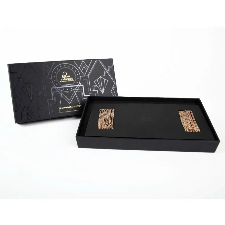 Chaînes dorées érotiques réglables sans nickel dans une boîte noire élégante, inspirées des cabarets new-yorkais.