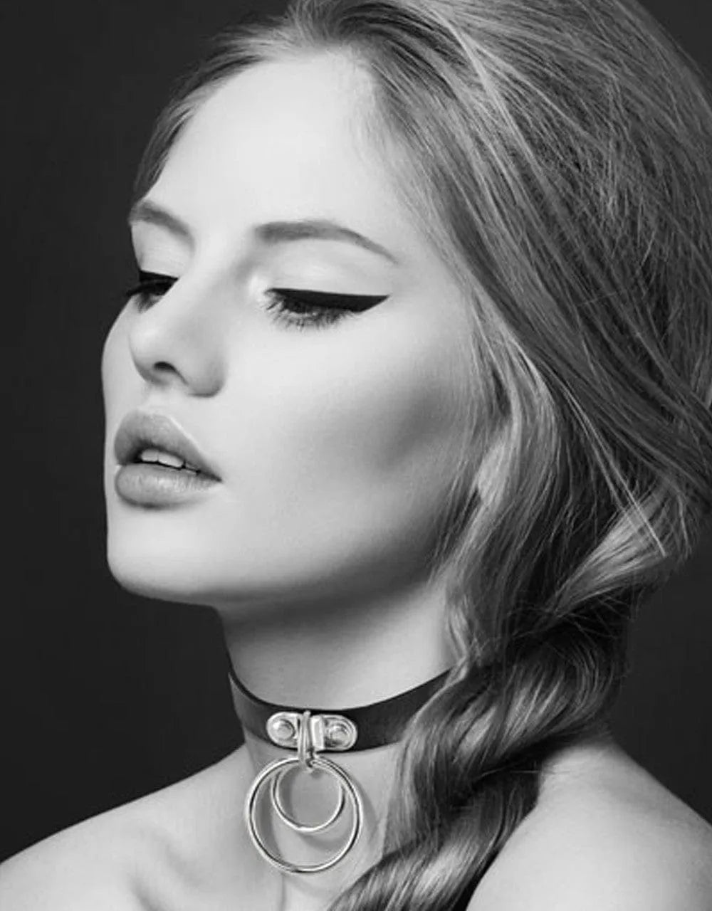 Collier en cuir noir avec double anneau argenté, porté par une femme, accessoire fétichiste SM élégant et réglable.