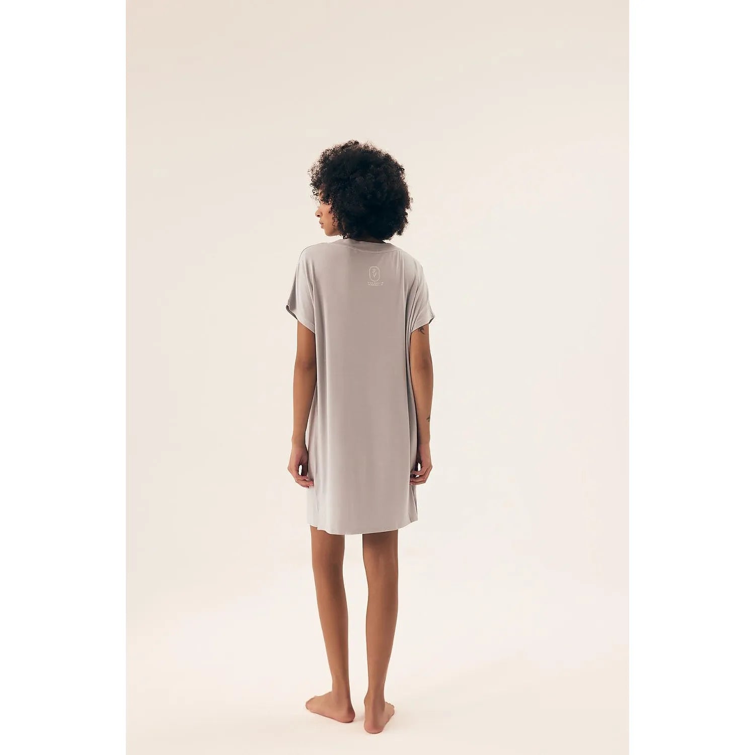 Chemise de nuit grise, manches courtes, décolleté en V, coupe ample, longueur genou, tissu léger et aéré.