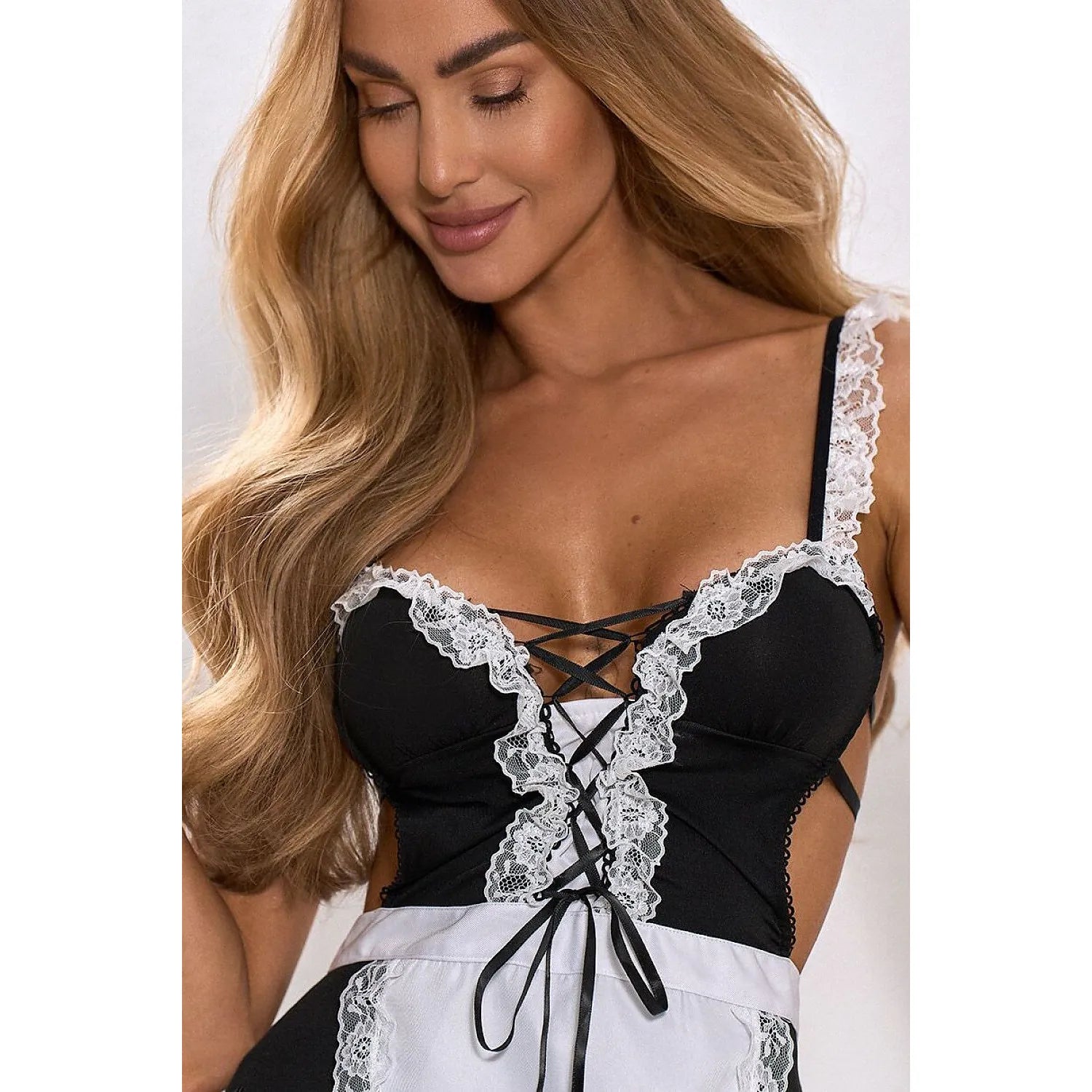 Femme portant un costume de femme de chambre en dentelle noire et blanche, design chic et élégant, cosplay soirée.