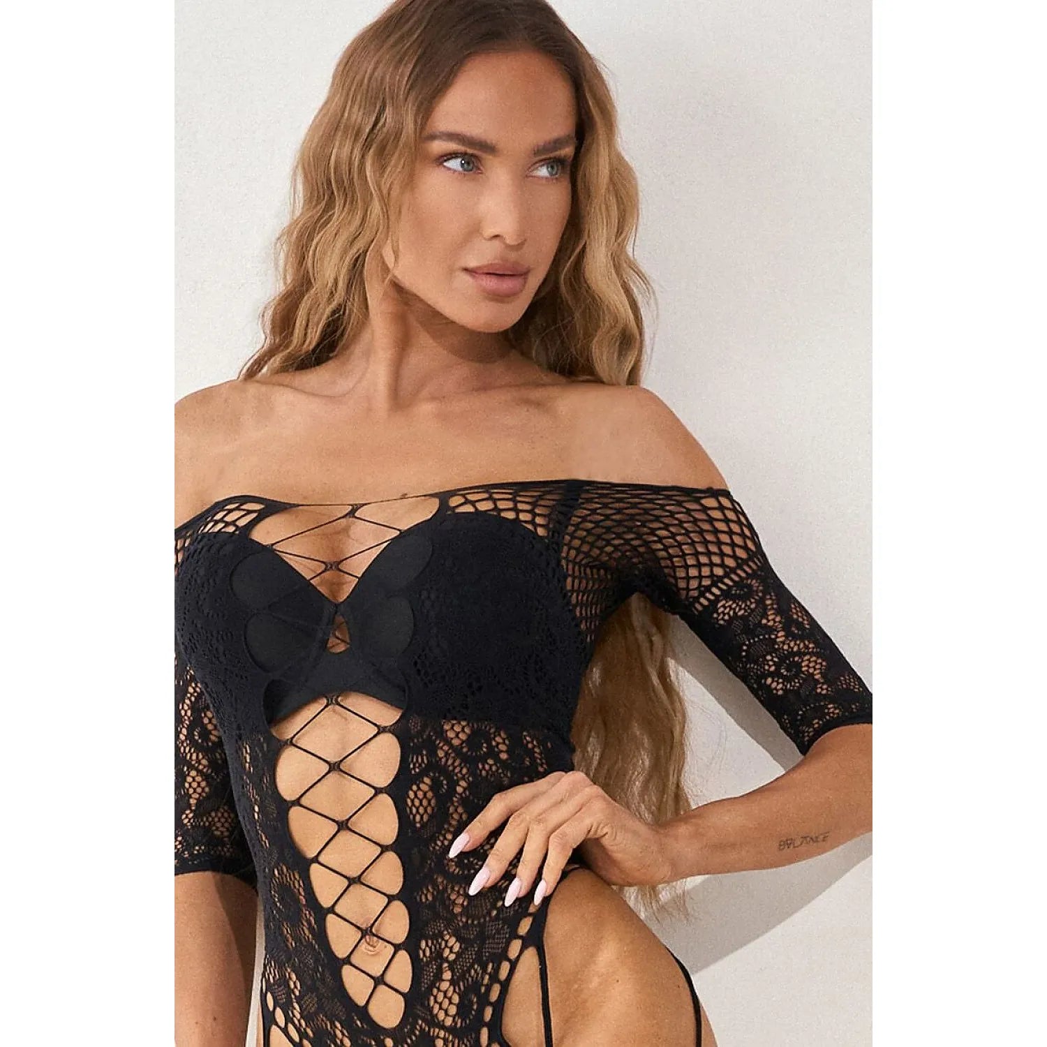 Bodystocking noir en maille élastique avec dentelle et laçages, manches trois-quarts, silhouette féminine élégante.