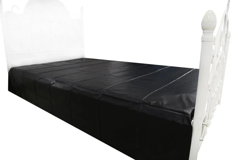 Drap noir imperméable en PVC sur lit blanc, conçu pour jeux adultes, protection optimale et usage jetable.