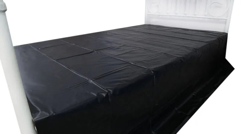 Drap jetable imperméable noir en PVC sur lit, idéal pour jeux adultes, protection optimale et hygiène assurée.