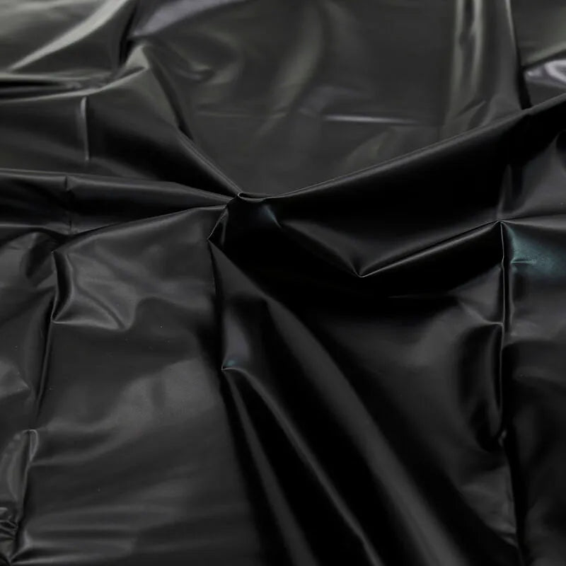 Drap jetable imperméable en PVC noir, texture lisse et brillante, idéal pour jeux adultes et protection optimale.