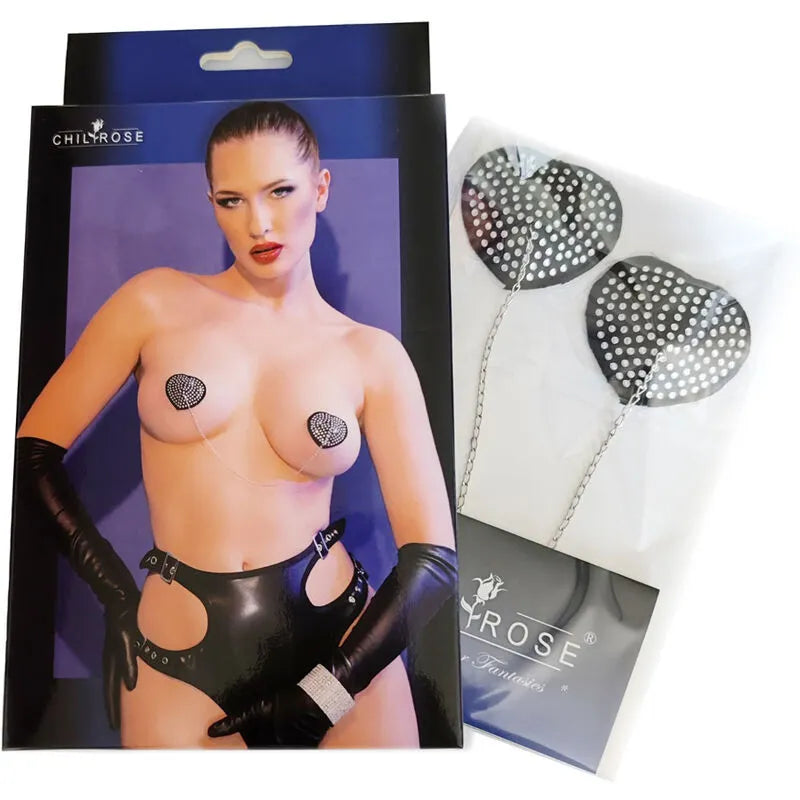 Cache-tétons argentés et noirs en forme de cœur, ornés de strass, sur fond bleu avec modèle en lingerie noire.