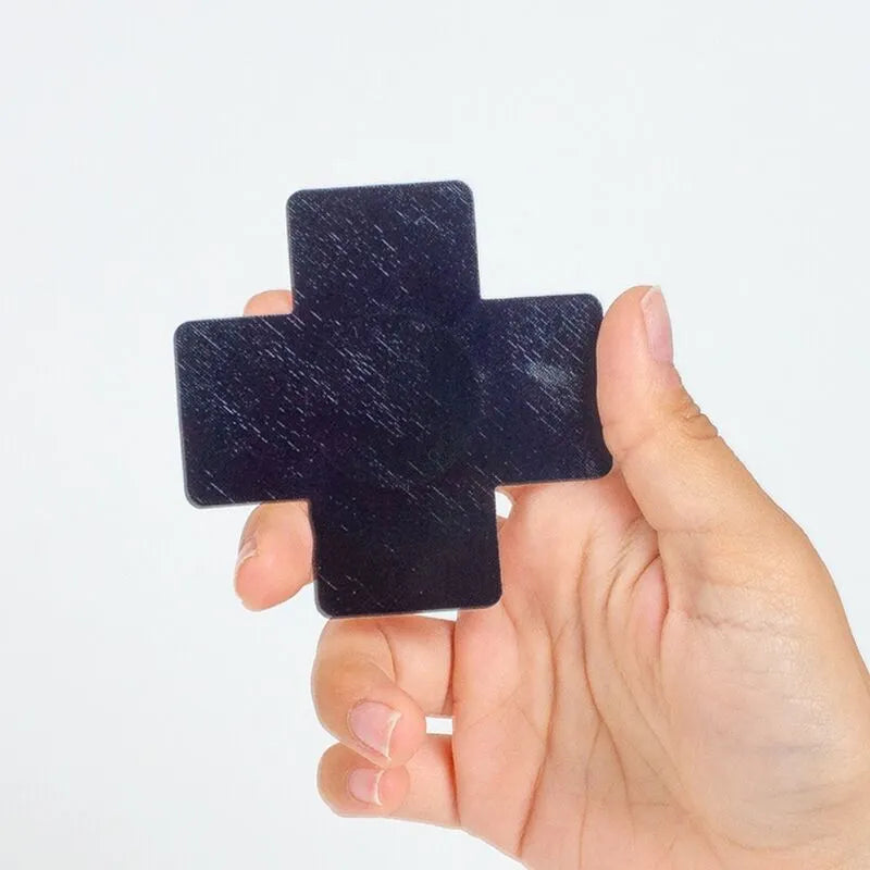 Cache-tétons holographiques noir rose en forme de croix, parfaits pour soirées et festivals, tenus dans une main.