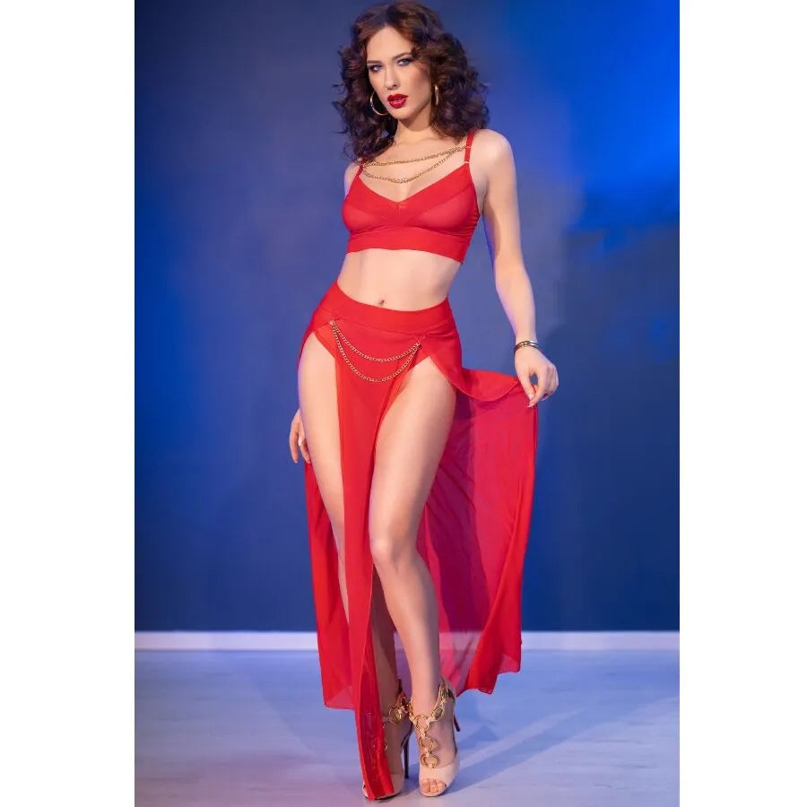 Ensemble rouge en tulle avec top à chaînes dorées et jupe fendue, accessoirisé de tongs élégantes.