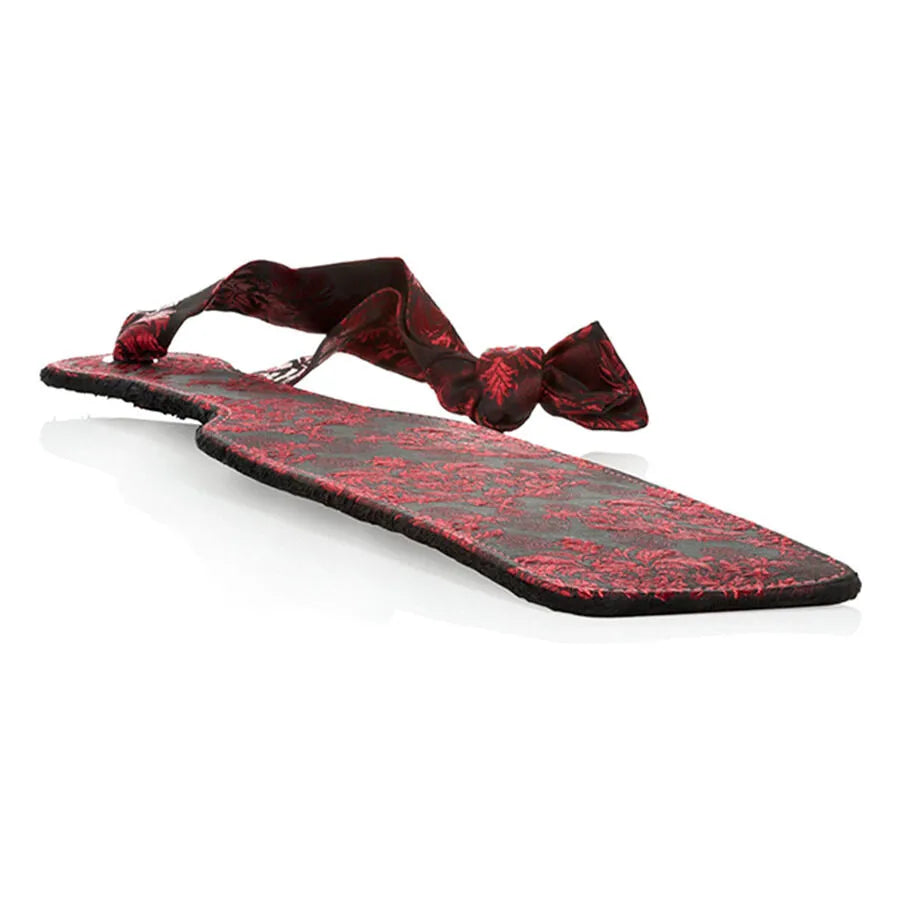 Raquette BDSM Scandal en brocart rouge et noir, design élégant avec ruban de satin pour prise ou fixation.