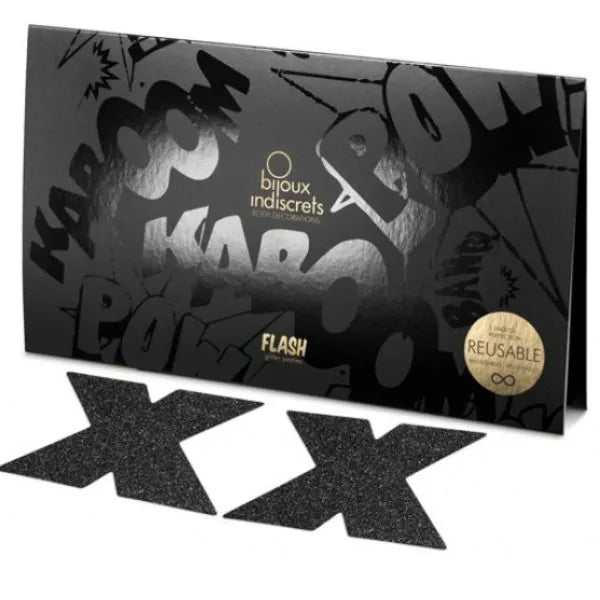 Nipple covers noirs en forme de croix, pailletés et réutilisables, sur fond de boîte noire avec motifs graphiques.