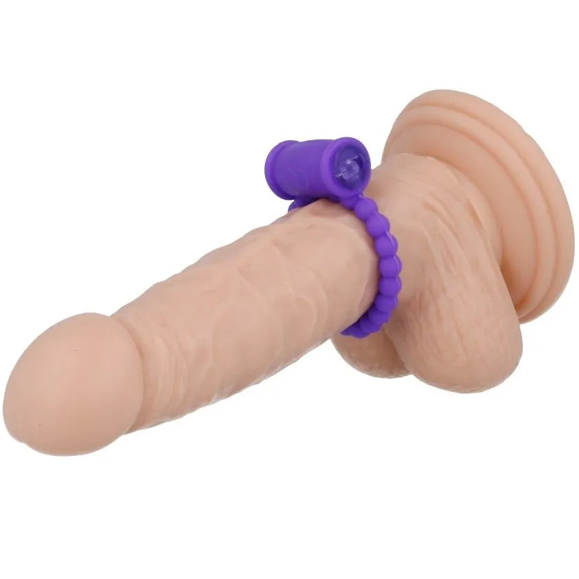 Anneau vibrant violet en silicone sur pénis factice, flexible et confortable, pour stimulation clitoridienne et vaginale.