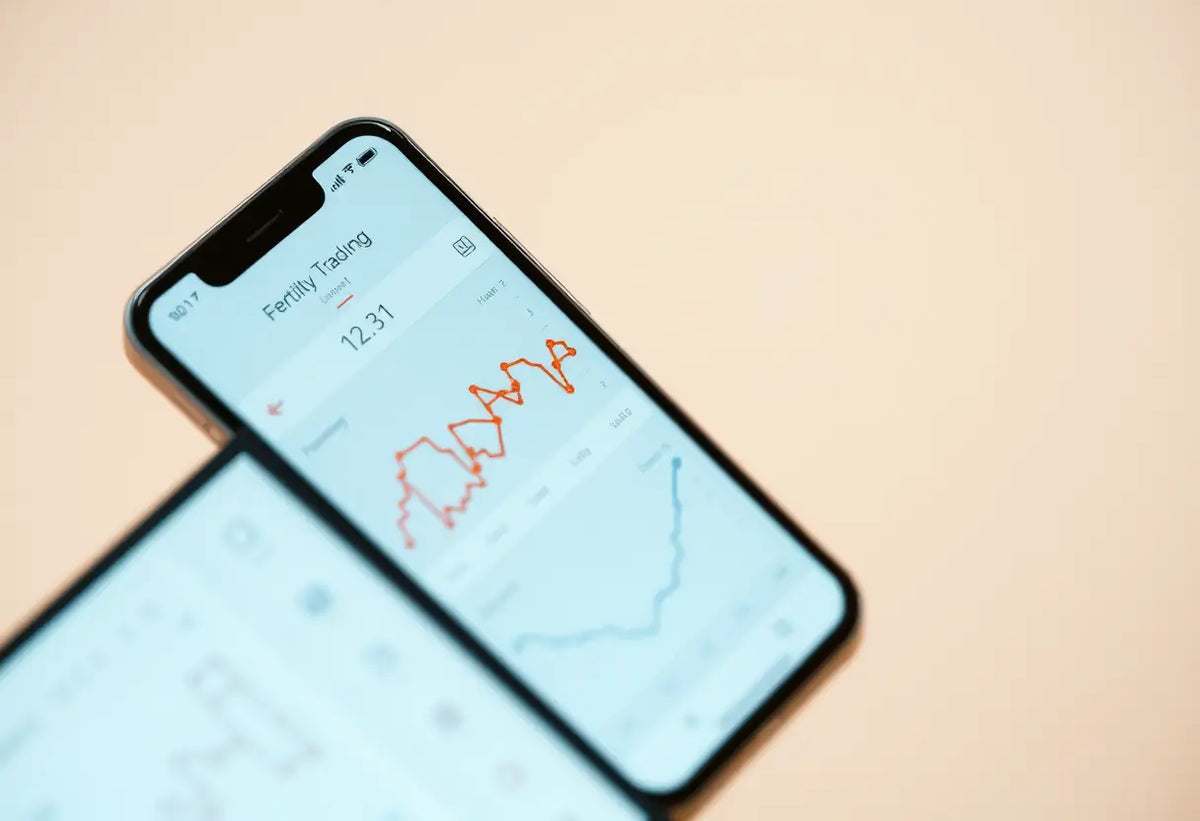 Un smartphone affiche une application de suivi de la fertilité avec des graphiques et des données