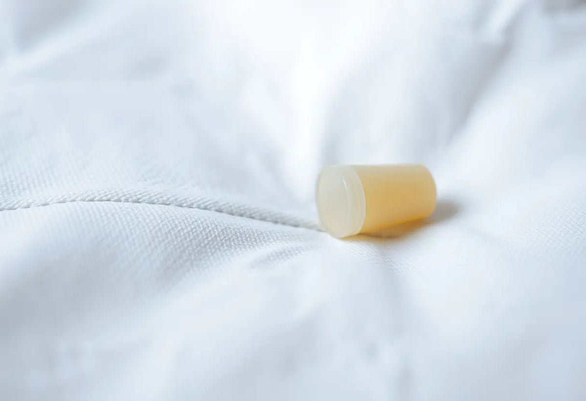Petit cylindre de plastique posé sur un tissu blanc