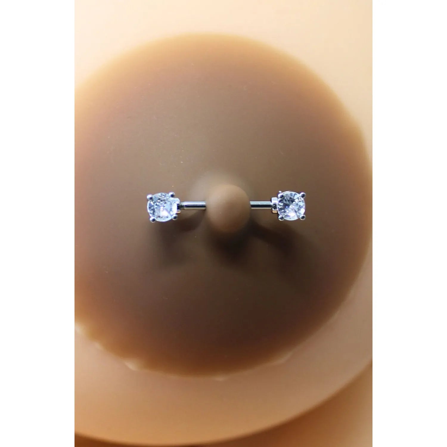 Cache-tétons silicone peau foncée, piercing barre faux diamants ronds, élégance discrète et réutilisable.
