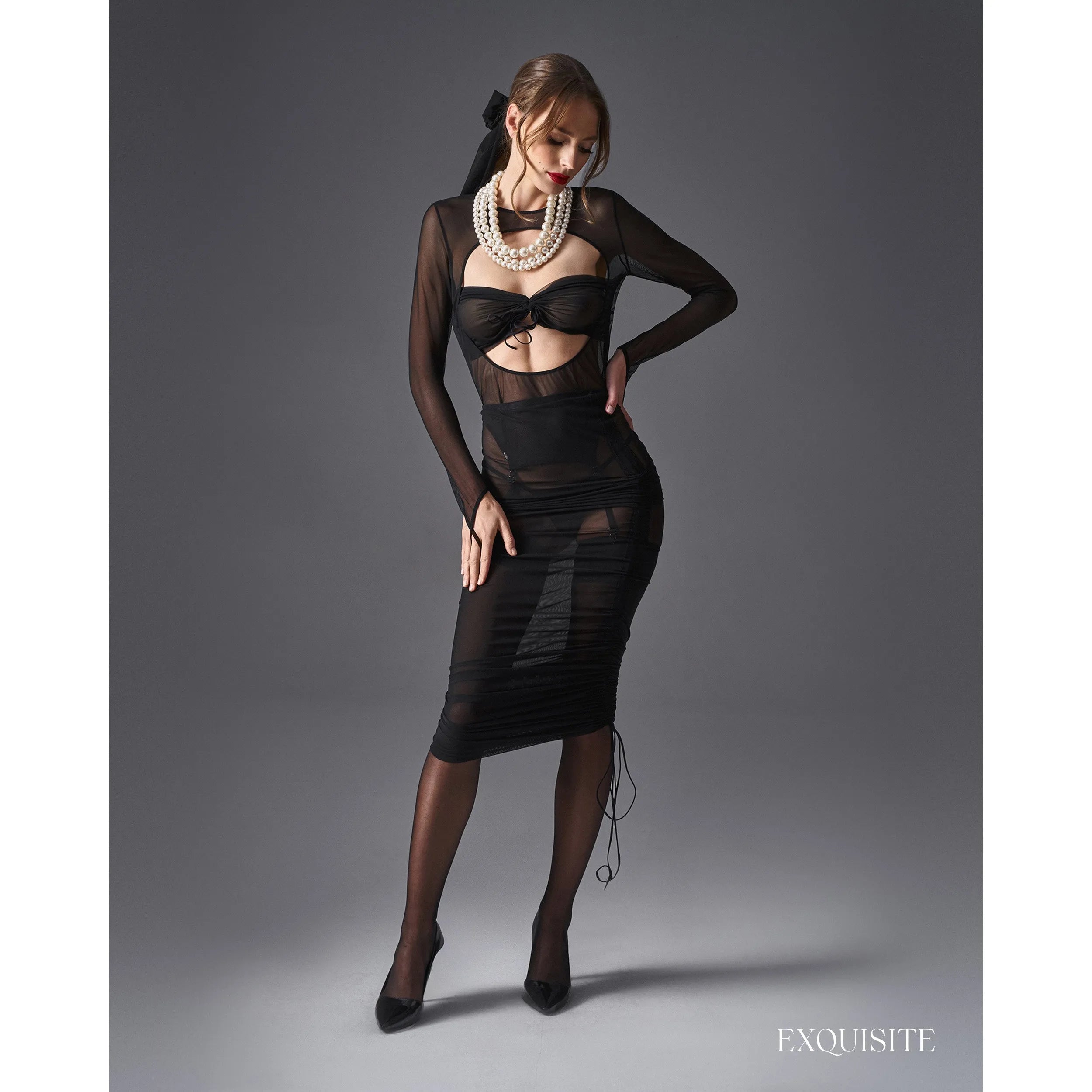 Blouse Aurorium noire, manches longues, tissu extensible, découpe audacieuse, jarretelles détachables, élégance moderne.