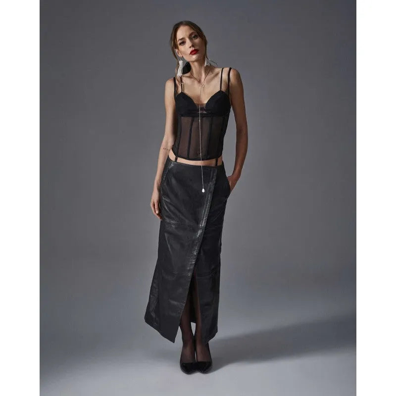 Corset noir profond en maille élastique avec baleines verticales et bonnets rembourrés, porté par une femme élégante.