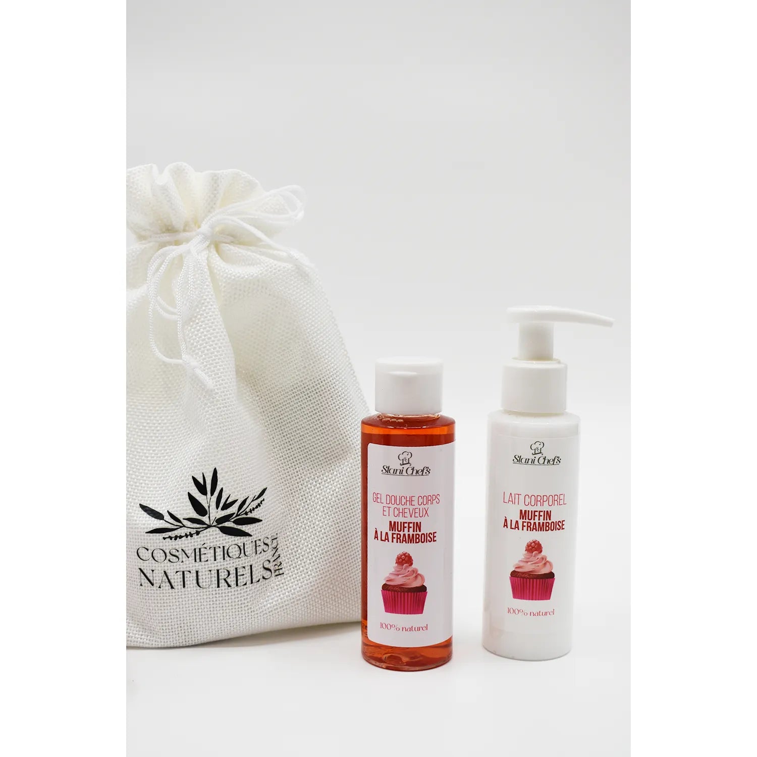 Coffret découverte muffin à la framboise avec lait corporel et gel douche, flacons blancs et roses, sac en tissu.