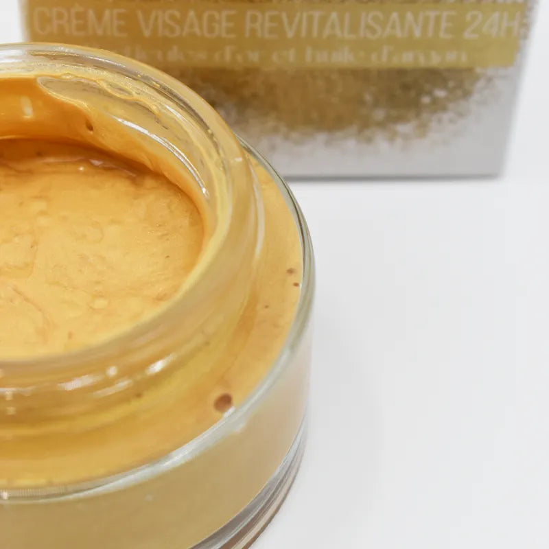 Crème visage revitalisante 24h or et argan, pot transparent, texture dorée, soin peau mature lumineuse.