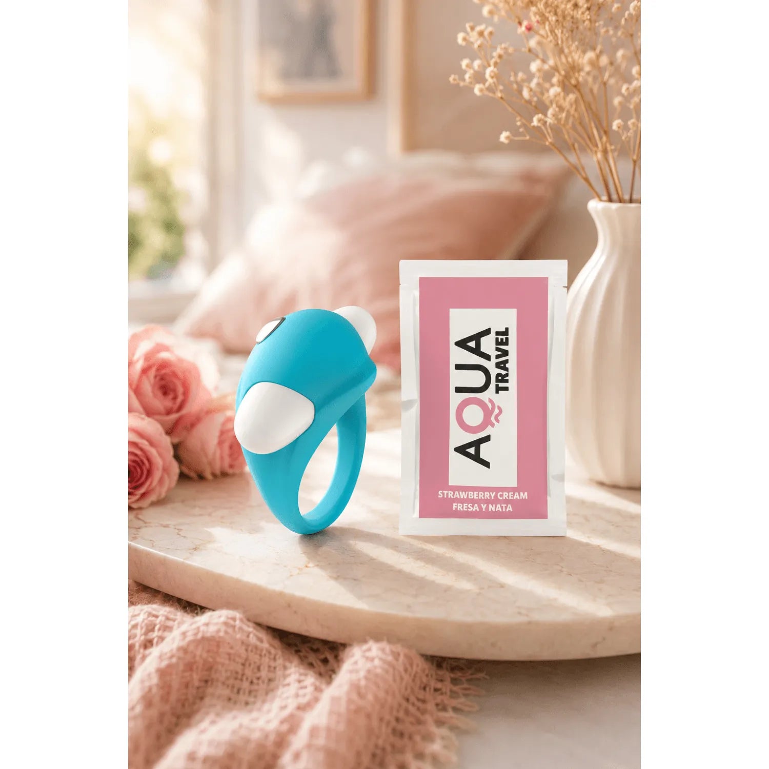 Cockring vibrant turquoise dauphin en silicone pour stimulation clitoridienne et pénienne, posé sur une table.