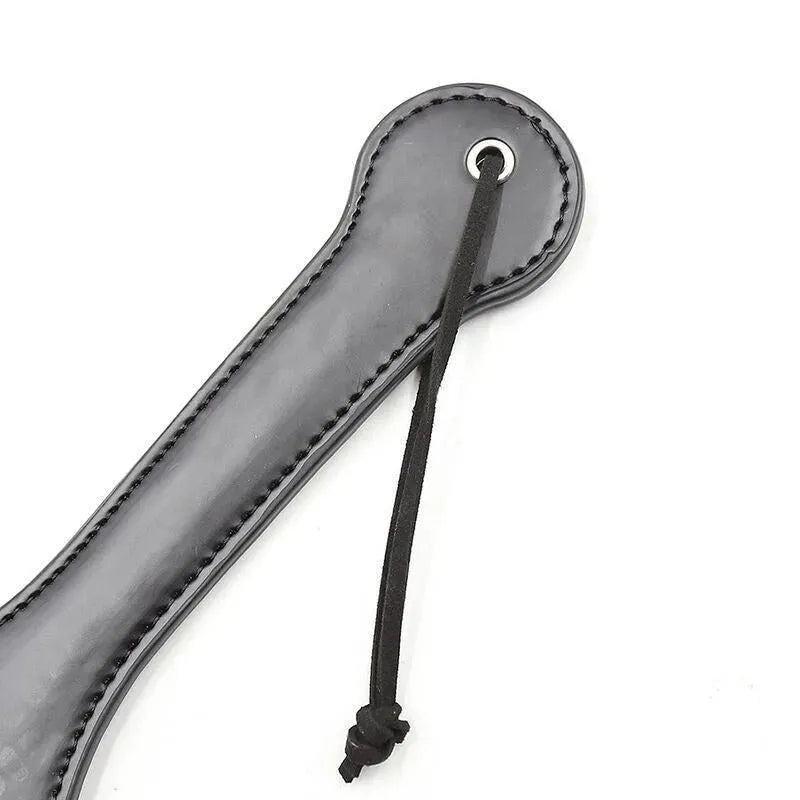 Paddle BDSM noir en forme de cochon, sans phtalates, avec lanière, accessoire Ohmama pour moments intimes sécurisés.