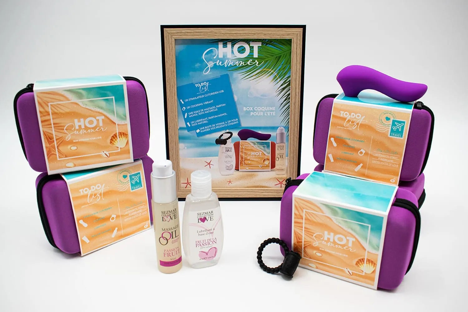 Box Couple Été avec stimulateur violet, anneau noir et huile de massage fruit de la passion, ambiance estivale exotique.